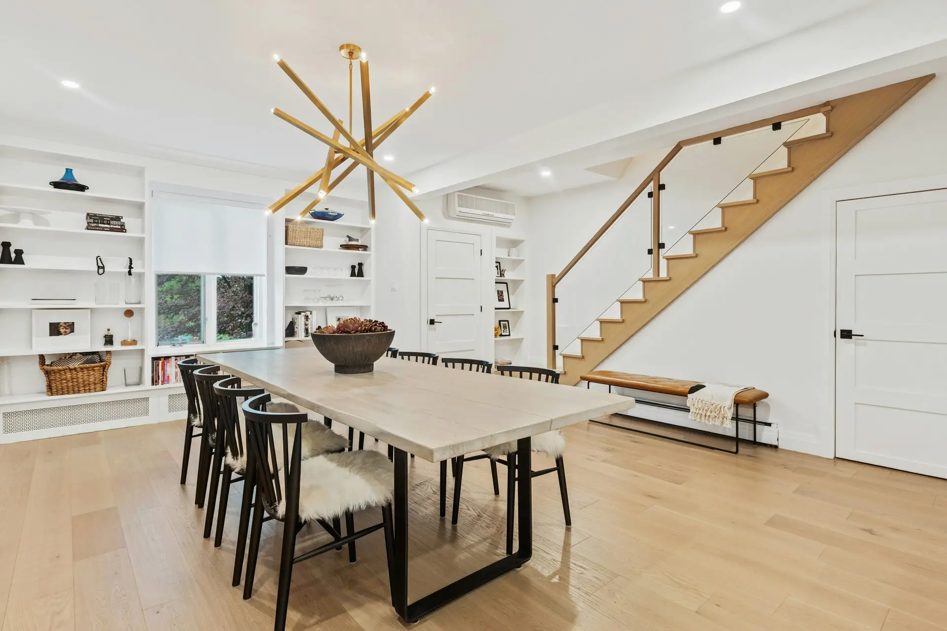 Dining room renovation with modern chandelier, built-in shelving, and hardwood floors in San Diego County