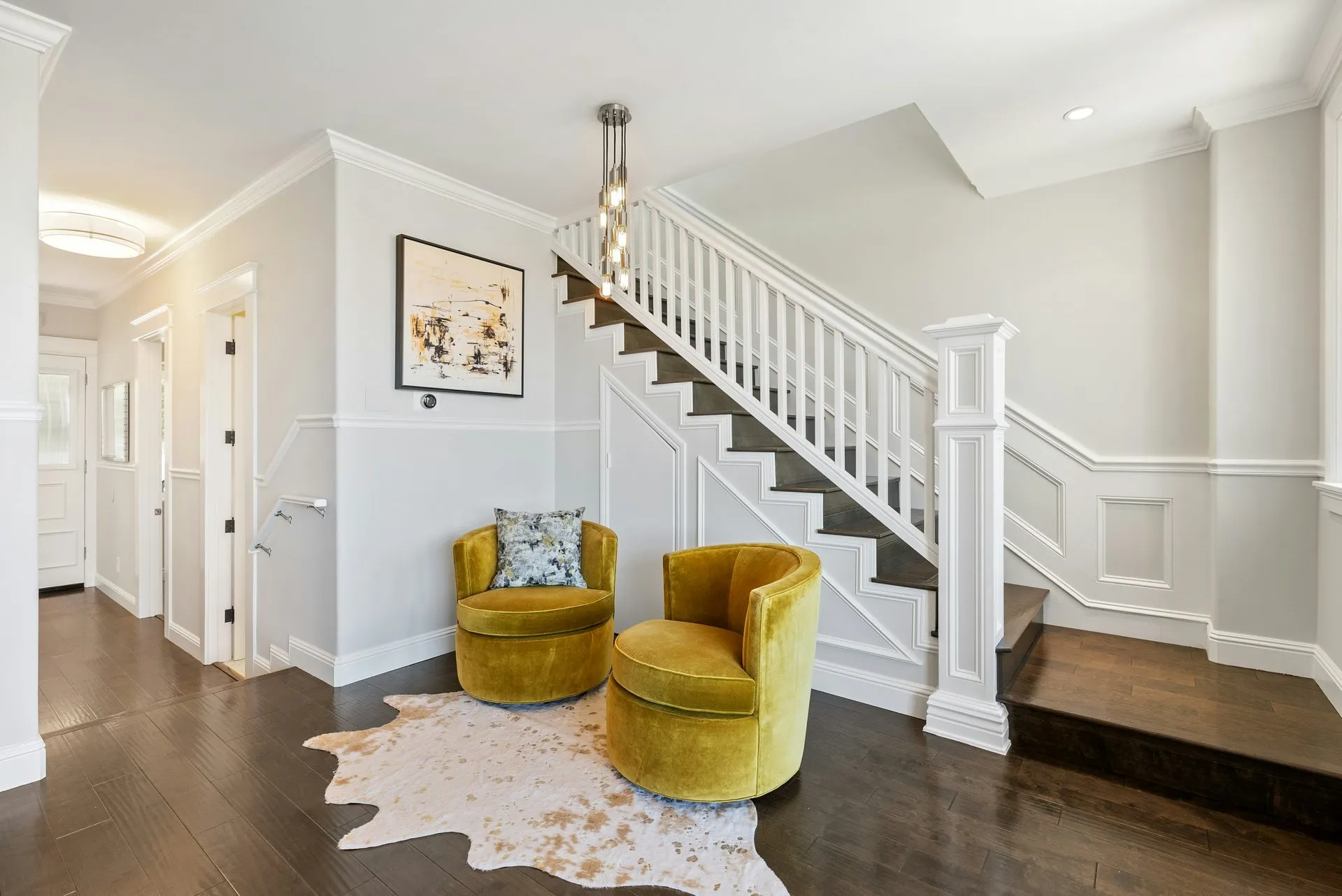 Home renovation featuring refinished hardwood floors, custom wainscoting, and updated staircase in San Diego