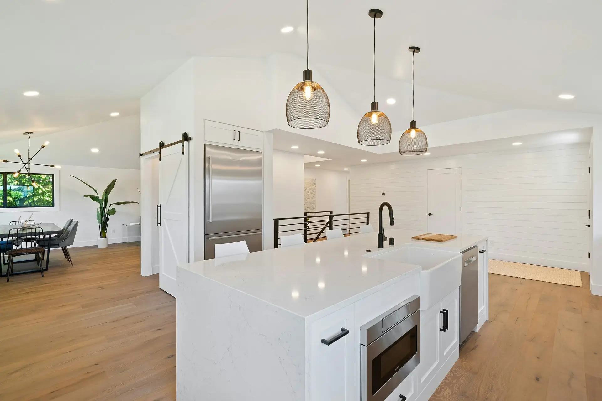Kitchen remodel with quartz waterfall island, pendant lighting, and stainless steel appliances in San Diego